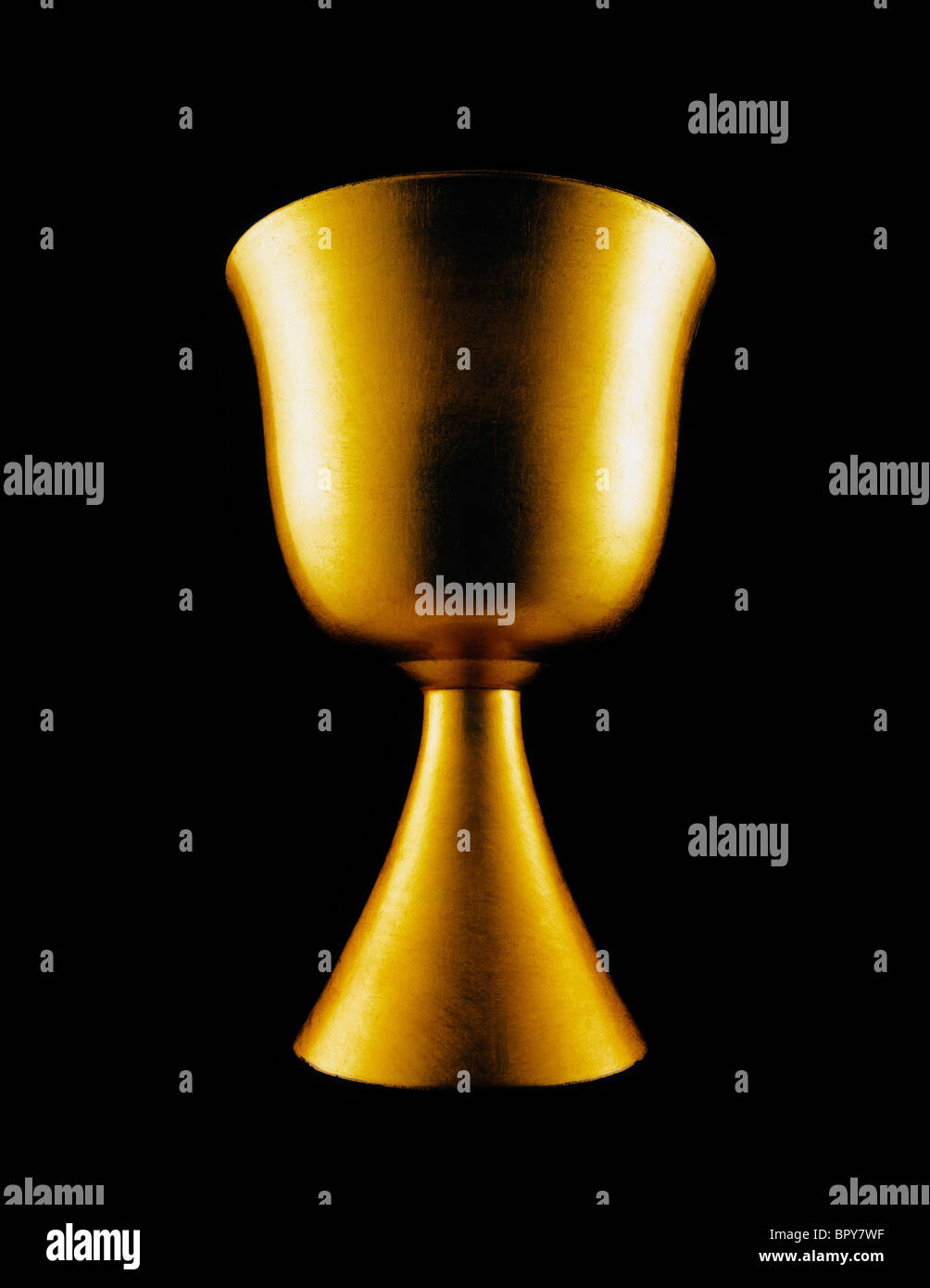 A gold chalice on black background capturing the glory and authority of the Christianity. Stock Photo