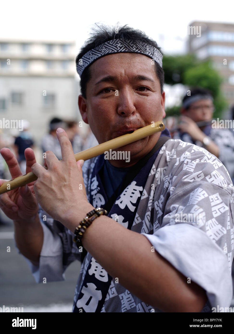 Man playing Japanese bamboo flute at Nebuta Matsuri summer festival of