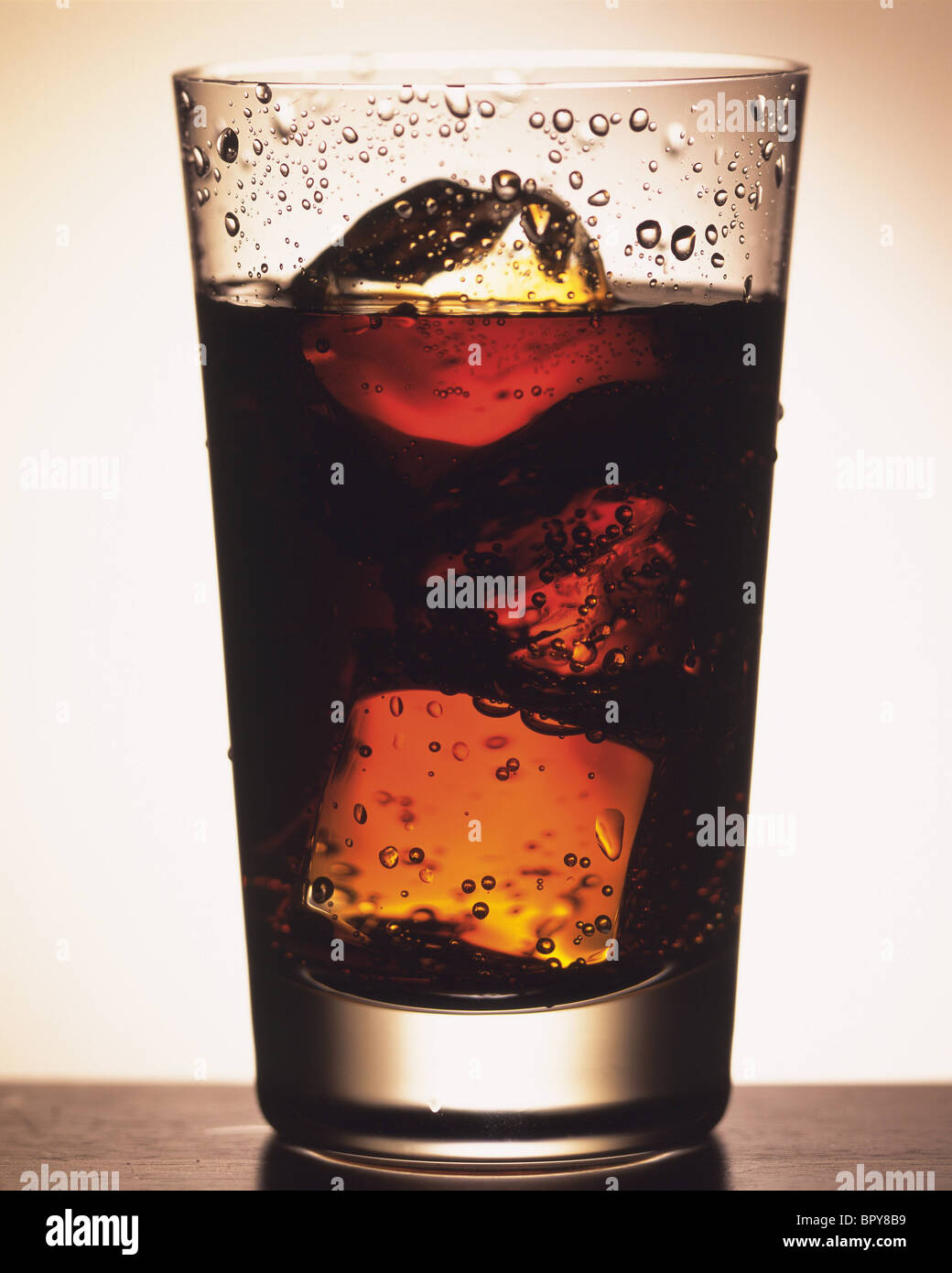 Cold glass of iced tea with ice cubes, isolated on white background