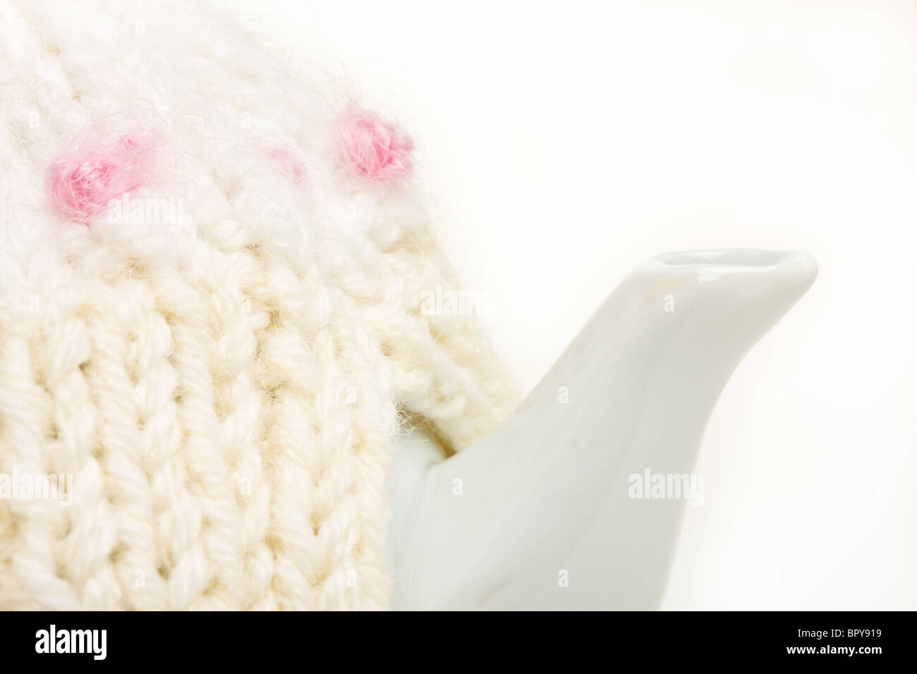 Abstract close up of tea pot and knitted tea cosy. Stock Photo