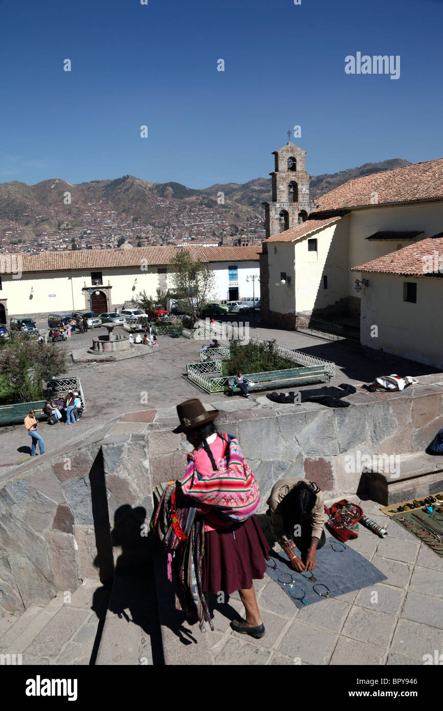 View over Plaza San Blas square and church, local Quechua woman setting up stall in foreground, Cusco, Peru Stock Photo