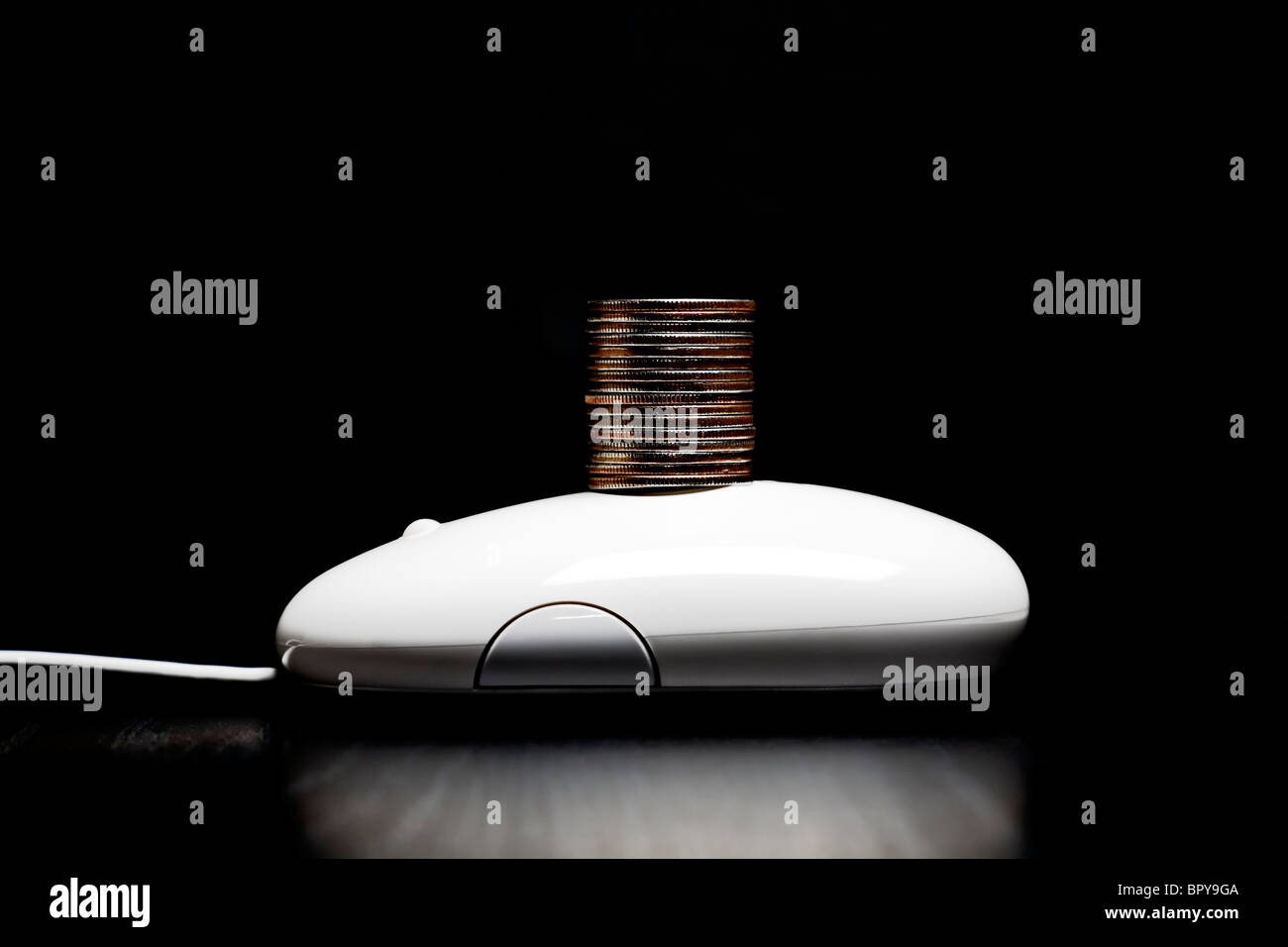 Computer mouse with a stack of coins Stock Photo
