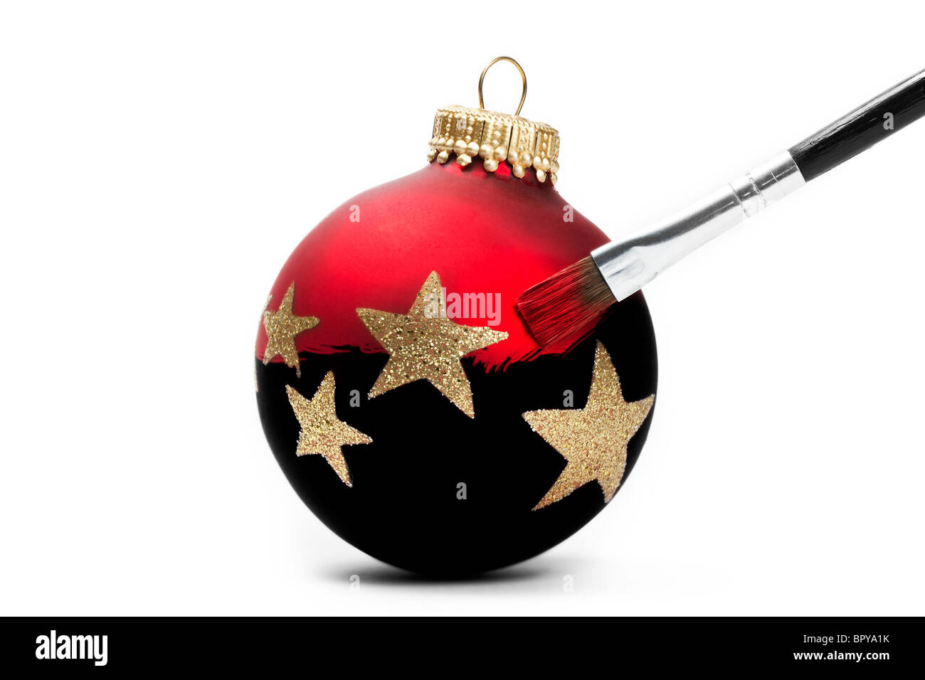 red Christmas ball gets his color with a brush on white background Stock Photo