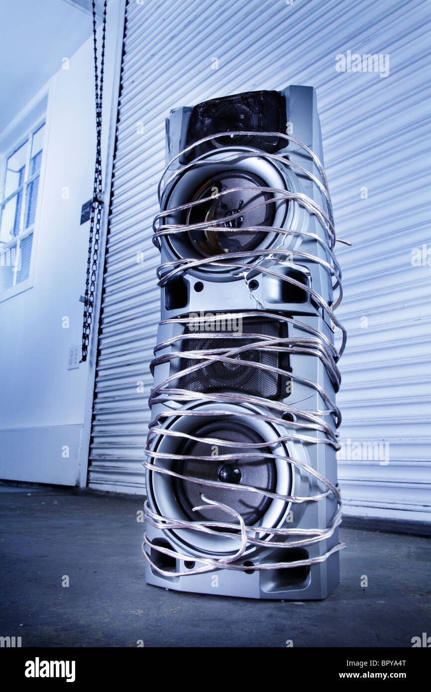 Broken speakers wrapped by wires in a industrial setting Stock Photo