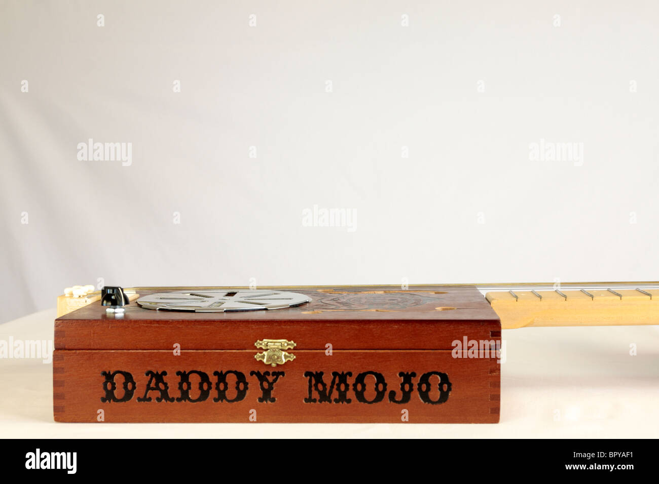 A Daddy Mojo 5 string cigar box guitar made in Canada in 2008 serial number 733 owned by Adam Gough from the band Traveller. Stock Photo