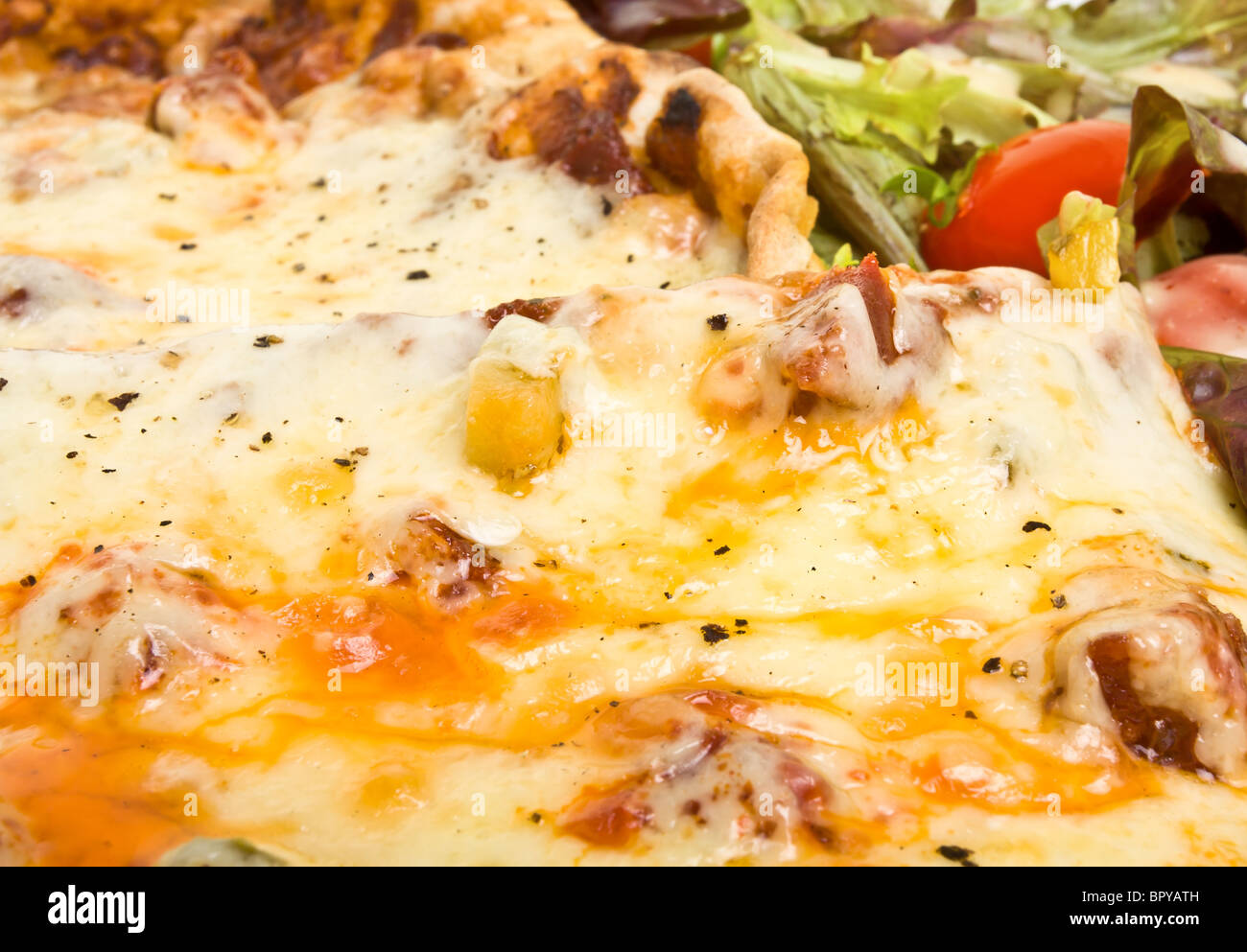 Vibrant tasty looking home made pizza and salad with dressing. Stock Photo