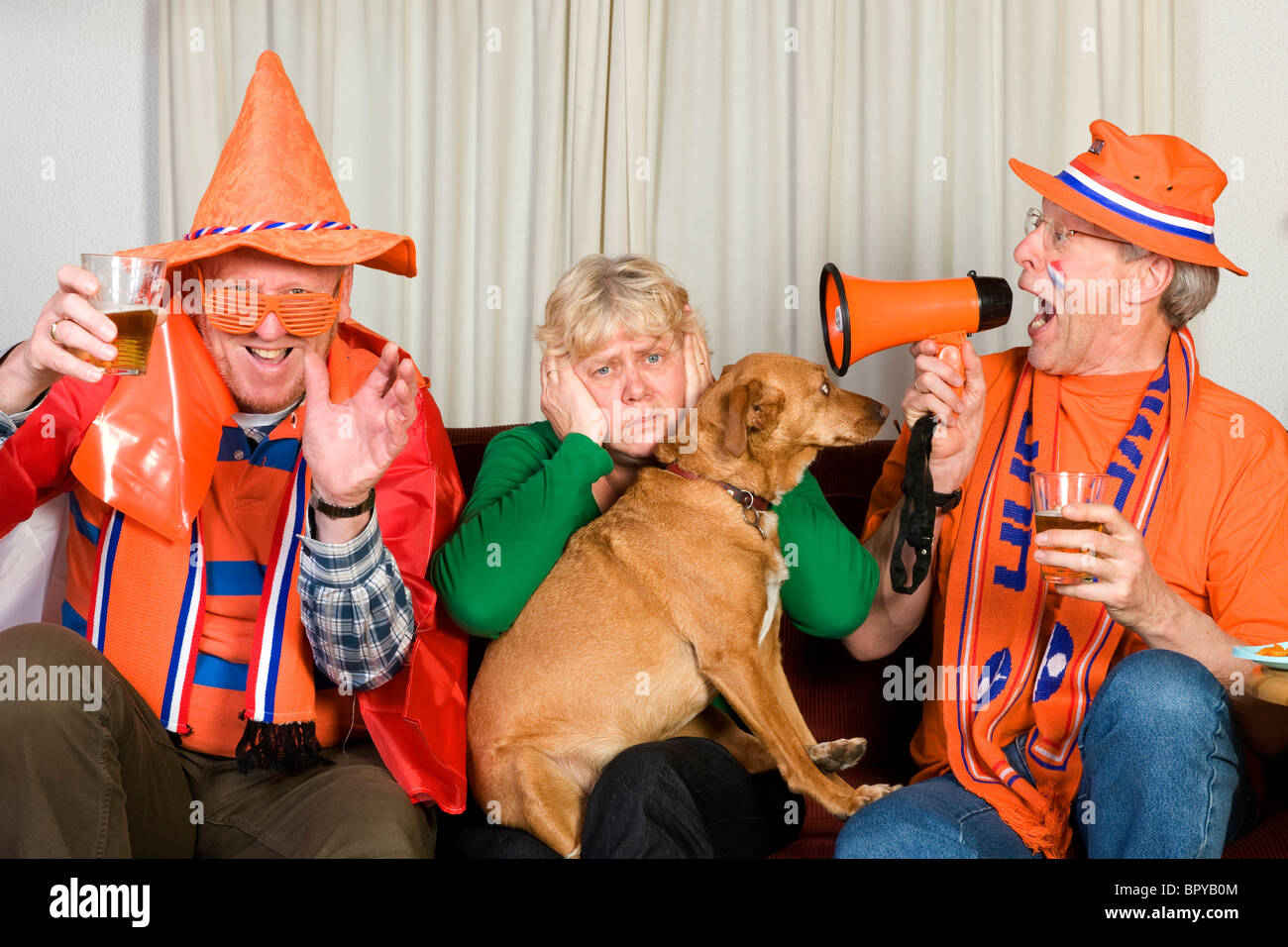 Dutch soccer fans looking to the television sitting on the bench Stock