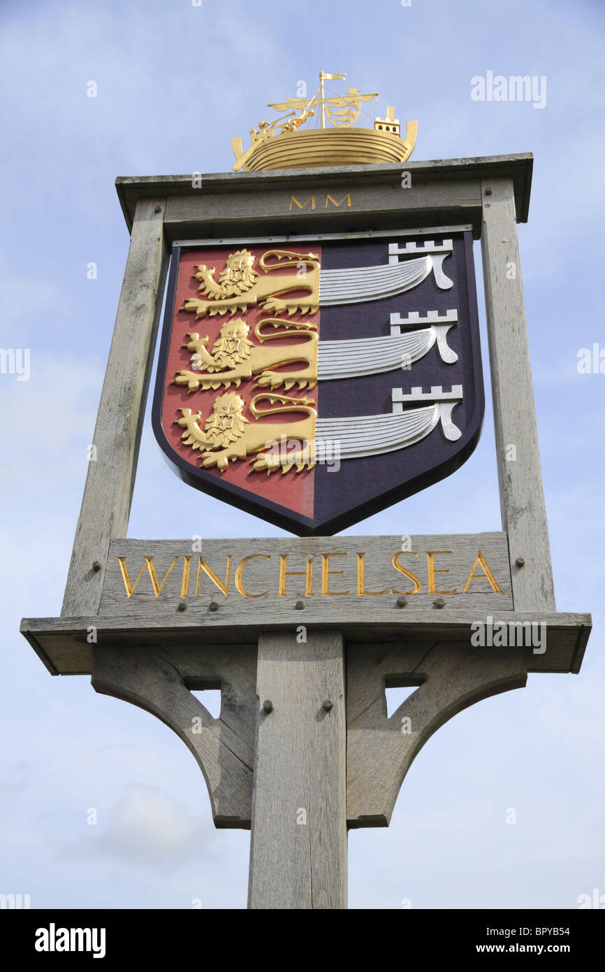 A hand carved oak sign displays Winchelsea Village Crest, East Sussex, England. Stock Photo