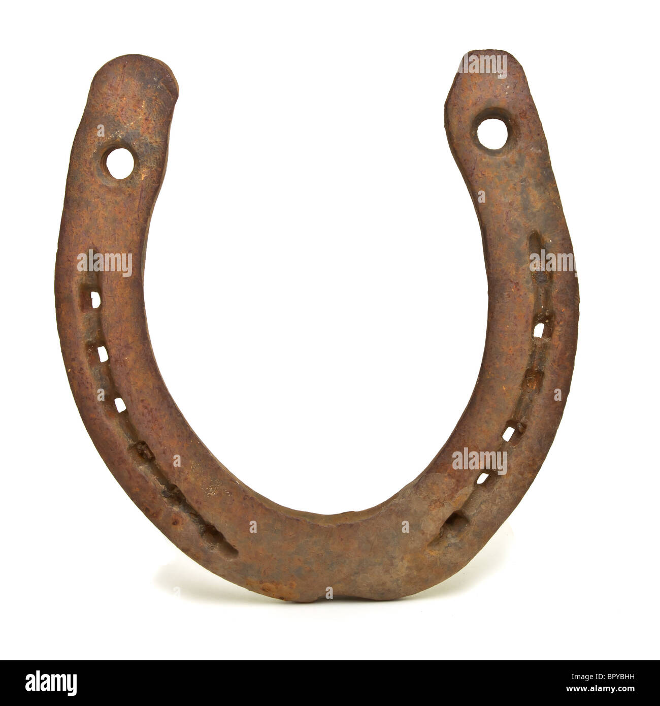 Rusty old lucky Horseshoe from low perspective isolated against white. Stock Photo
