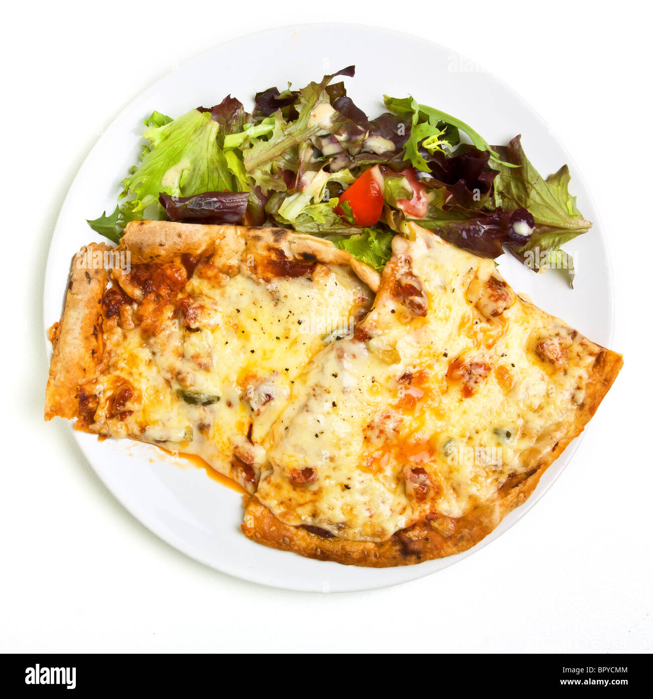 Vibrant tasty looking home made pizza and salad with dressing. Stock Photo