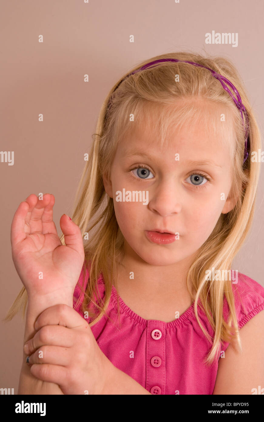 young girl showing physician where she hurt her wrist, holding her hand