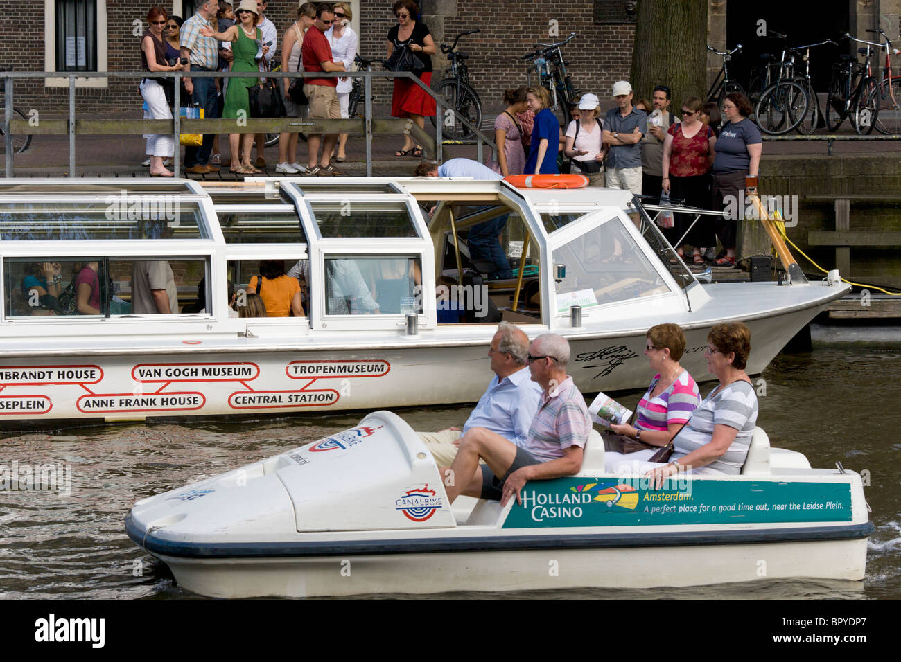 Amsterdam Prinsengracht, Princes Canal, Canal Hopper tour boat stop at Westerkerk and Anne Frank House. Canal Bike w. tourists Stock Photo