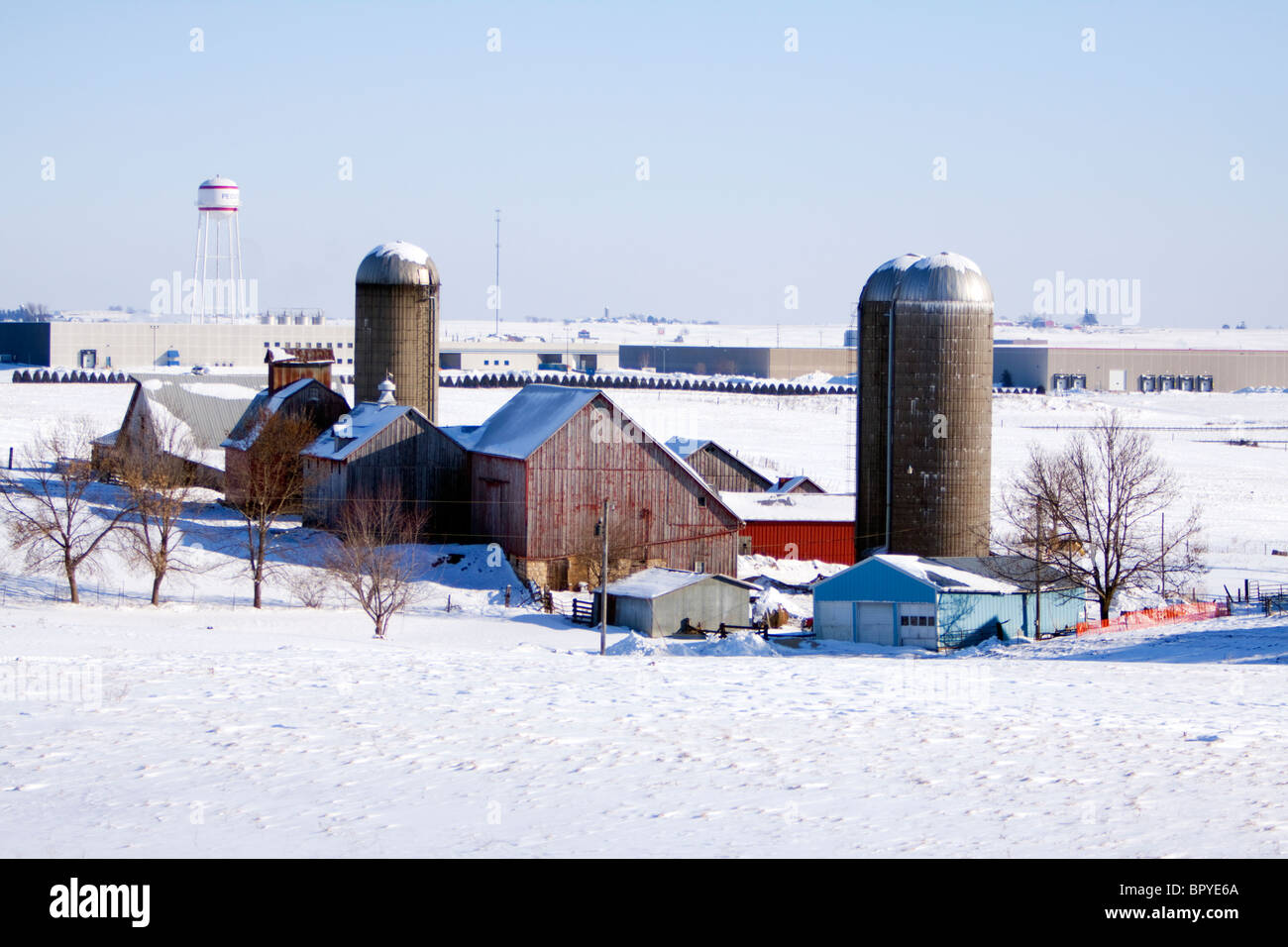 A barn in Iowa with an industrial park encroaching during winter. Stock Photo