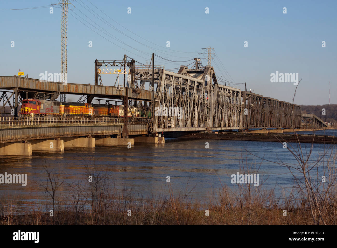 A BNSF freight train crosses the Mississippi River on a huge swing bridge at Fort Madison, Iowa. Stock Photo