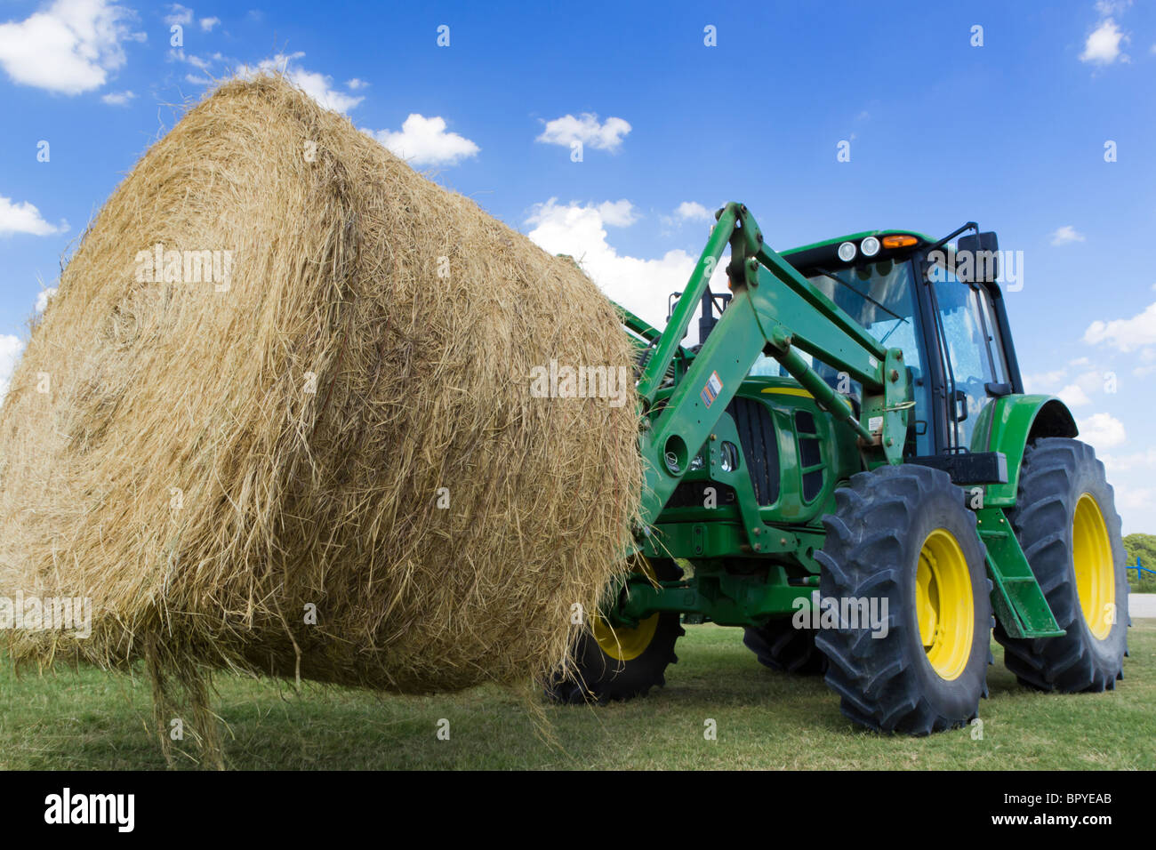 Tractor moving hay bale Stock Photo Alamy