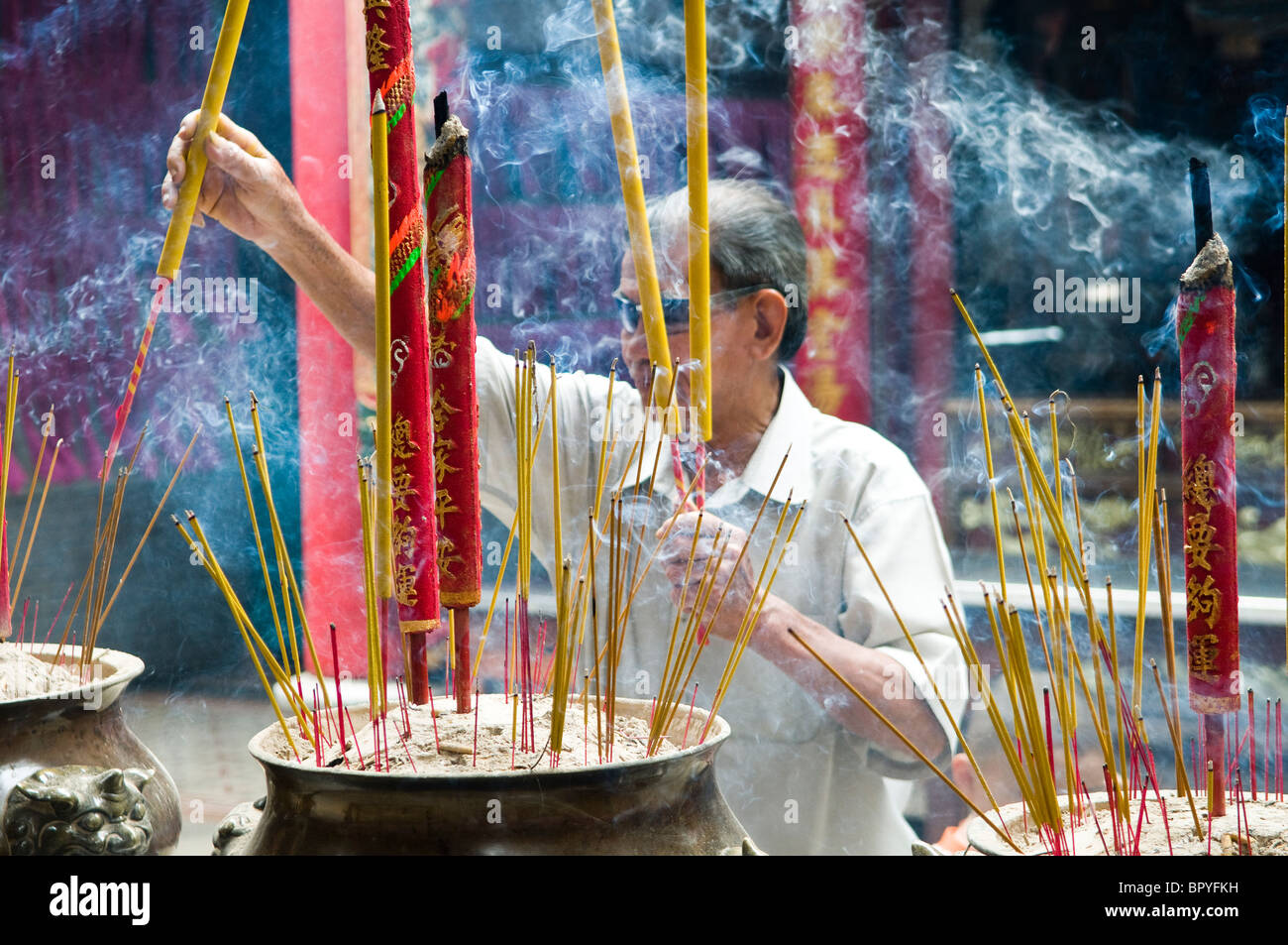 Lighting up the incense sticks in a Chinese temple in Saigon Stock