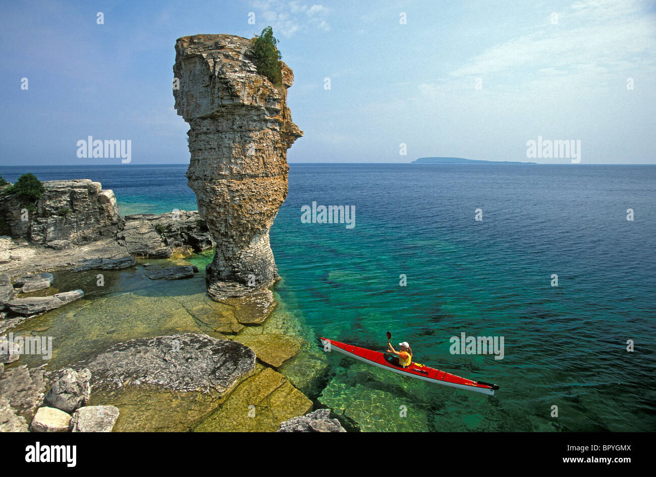 Young woman seakayaks past Flowerpot Island, Fathom Five National