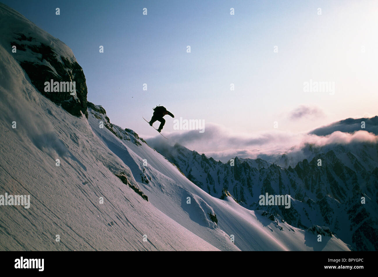 Cliff jump on snowboard Stock Photo