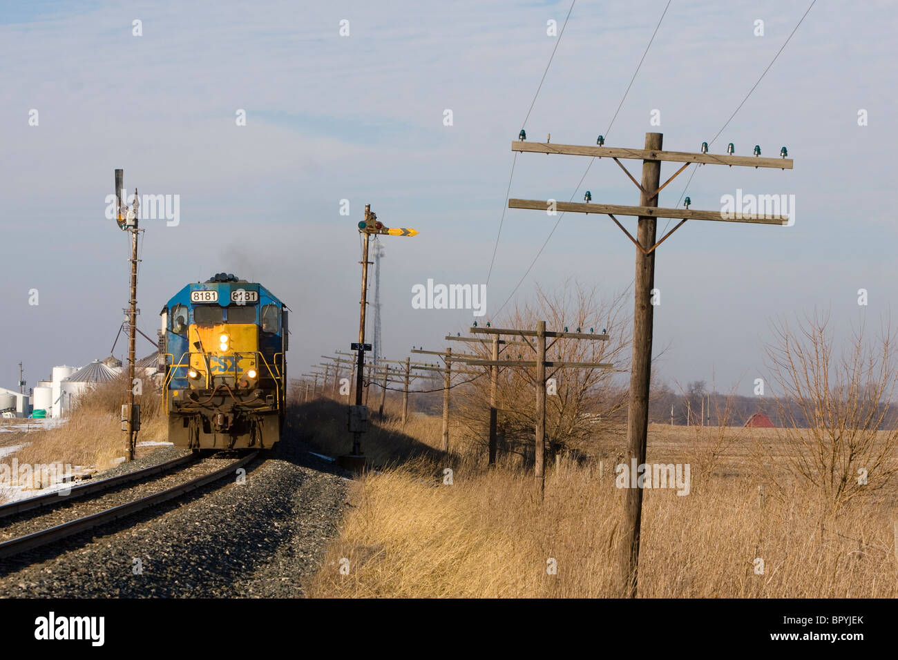 A CSX Transportation train rolls by a pair of vintage semaphore signals in rural Indiana. Stock Photo