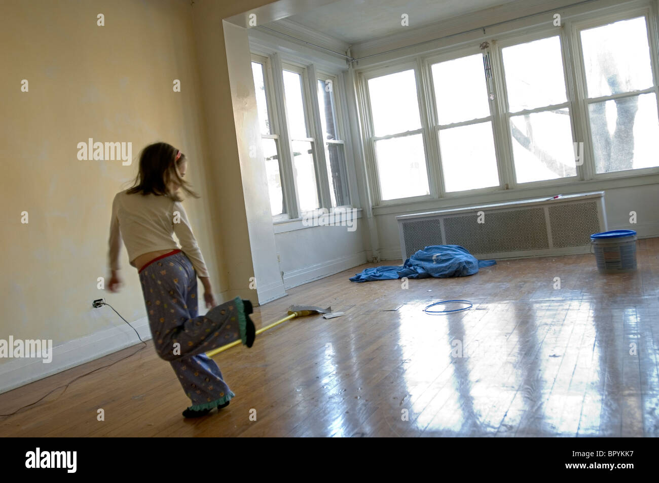 A young girl plays in an empty apartment undergoing renovations. Stock Photo