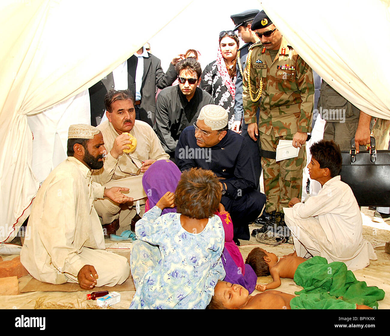 President, Asif Ali Zardari commiserates with a flood affected family at flood affectees relief camp in Dera Murad Jamali Stock Photo