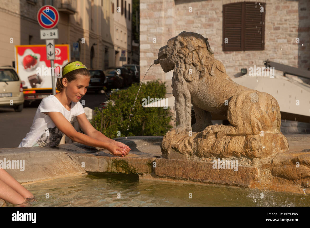 child cooling off by fountain in Assisi Italy Stock Photo