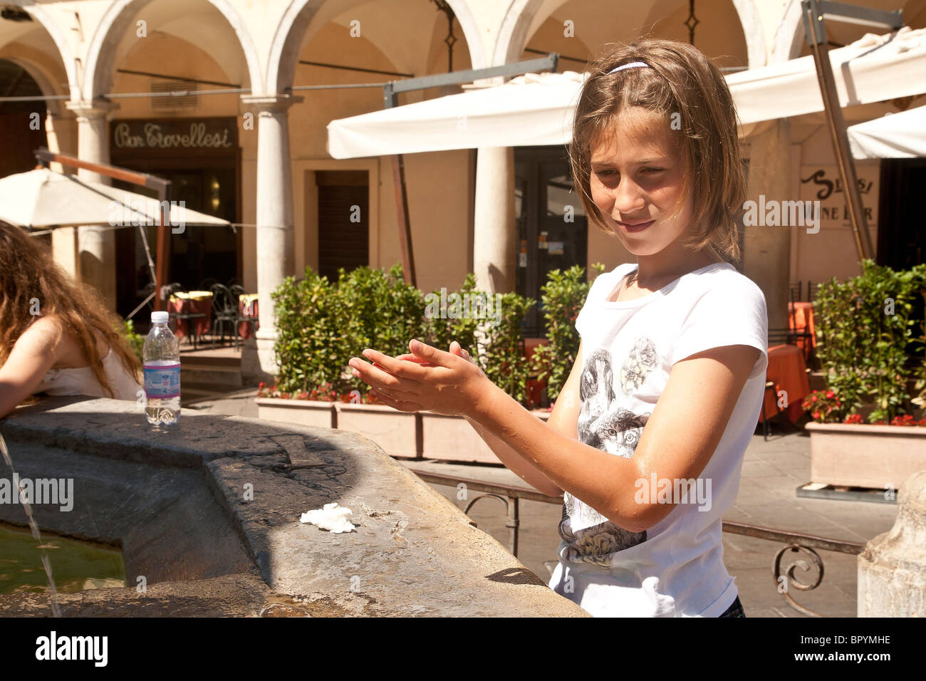 child cooling off by fountain in Assisi Italy Stock Photo