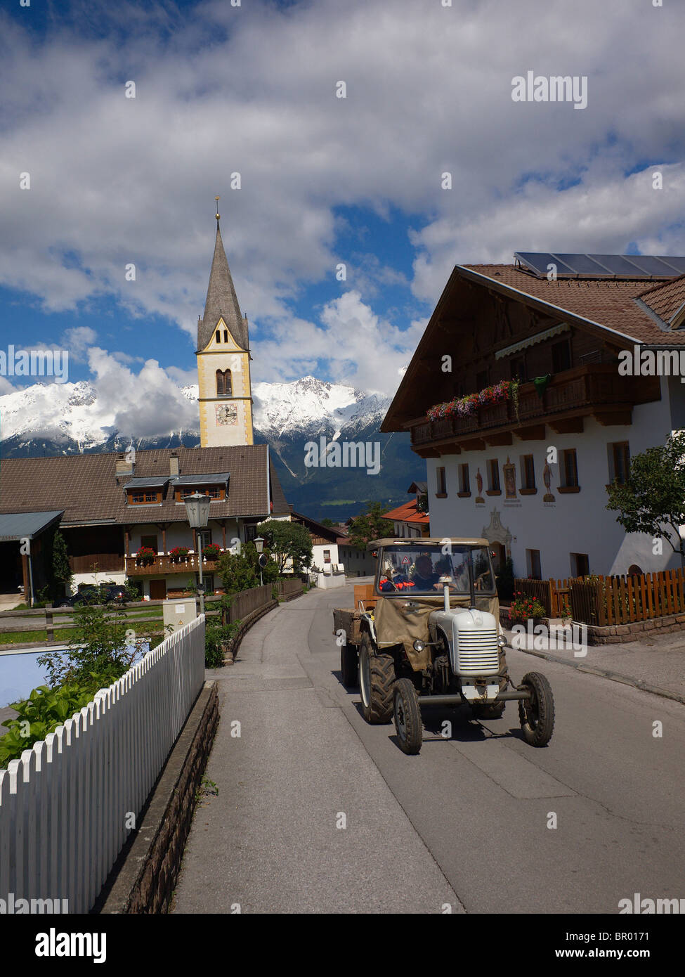 An elderly tractor being driven in the village of Sistrans near Innsbruck in the Austrian Tirol Stock Photo