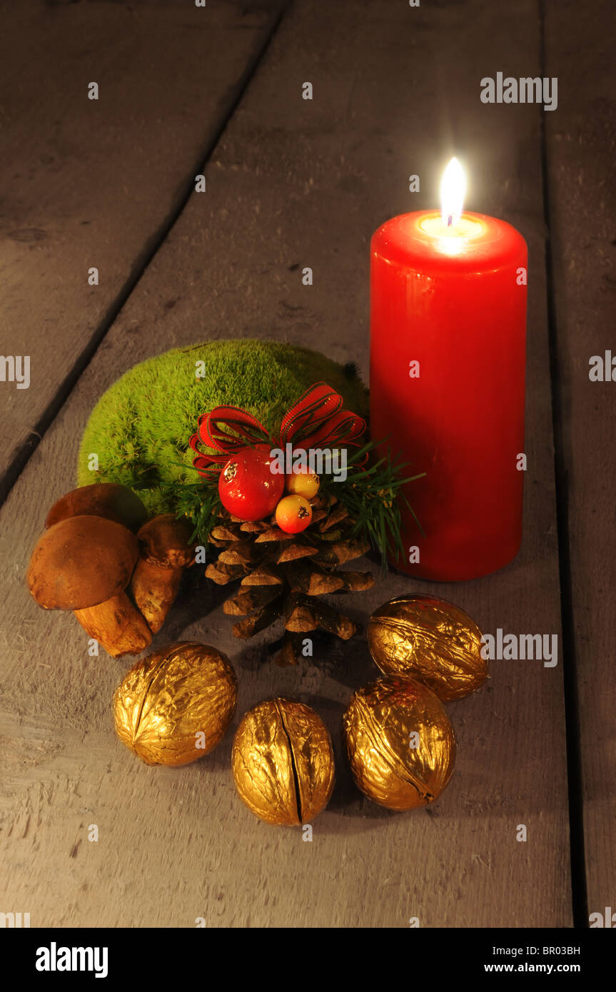 Christmas still life - simple scene with candle, decorative cone, mushrooms and golden walnuts Stock Photo