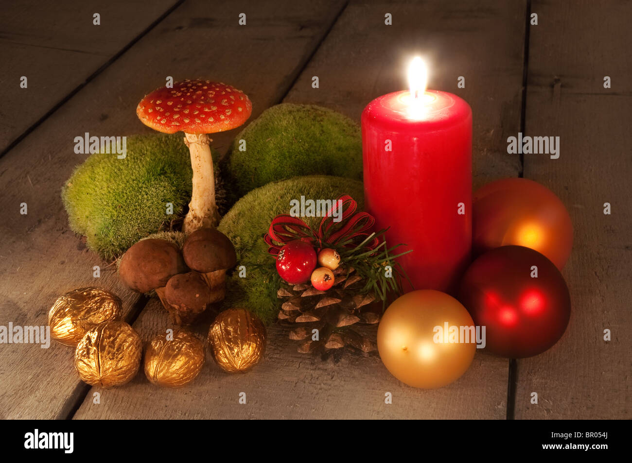 Christmas still life - simple scene with candle, decorative cone, mushrooms and golden walnuts Stock Photo