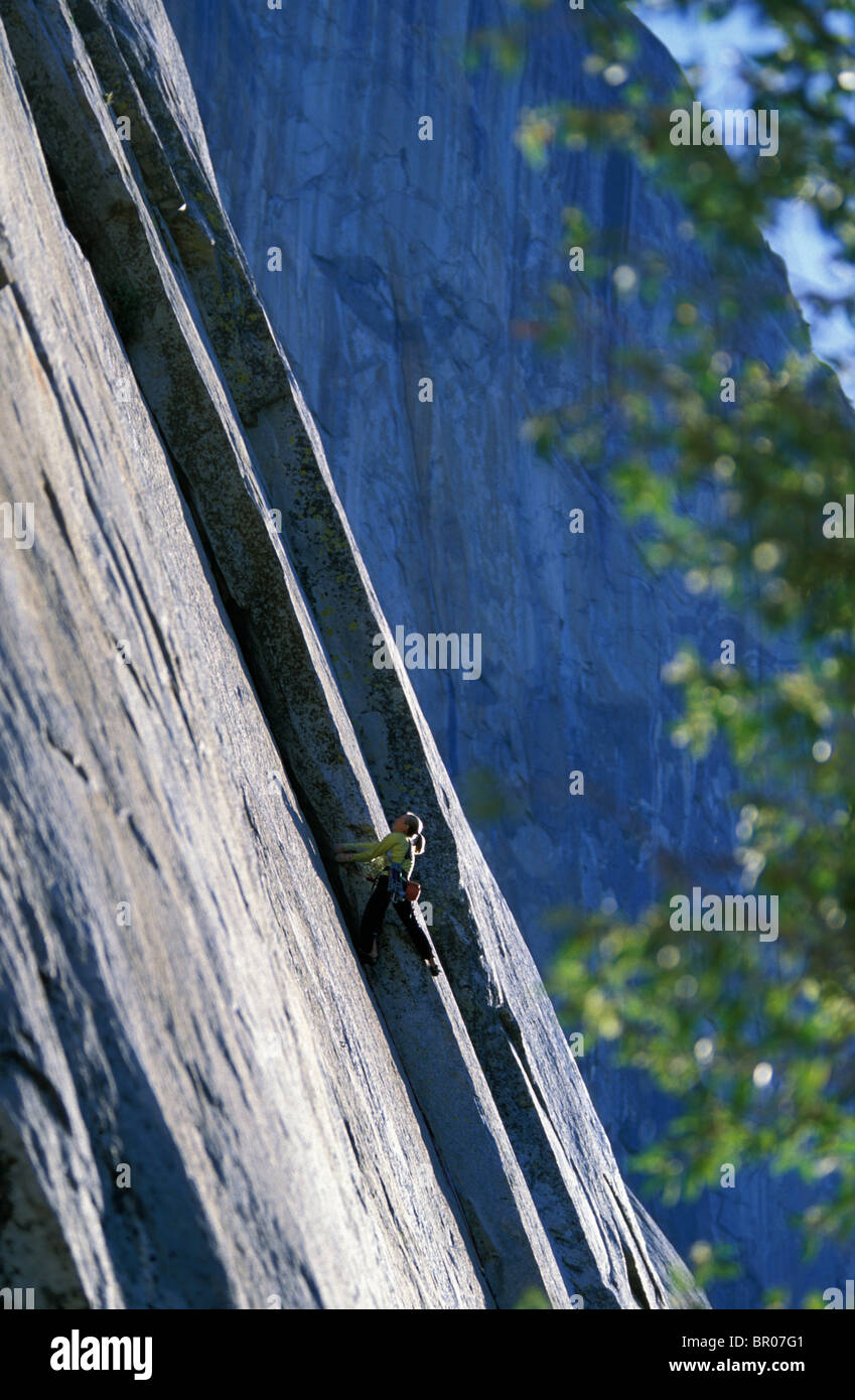 A female rock climber leading climbing a big granite wall in Yosemite
