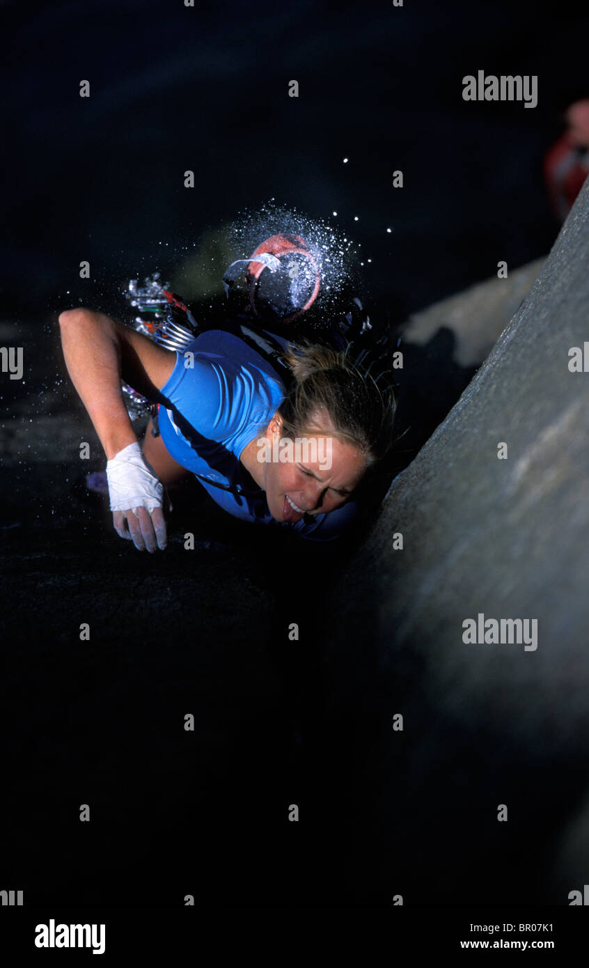 A female rock climber climbing a crack in a granite big wall in