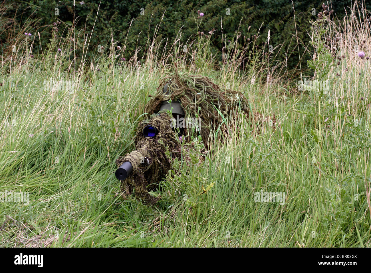 Hunter wearing ghillie suit for camouflage Stock Photo