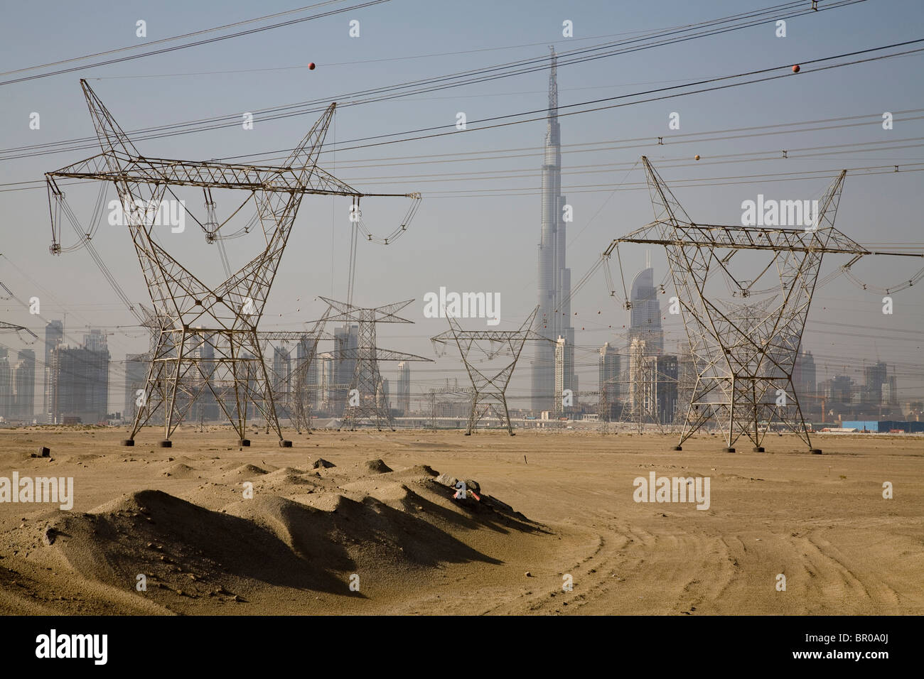 UAE, Dubai. Electricity towers and wires, with Burj Dubai in background
