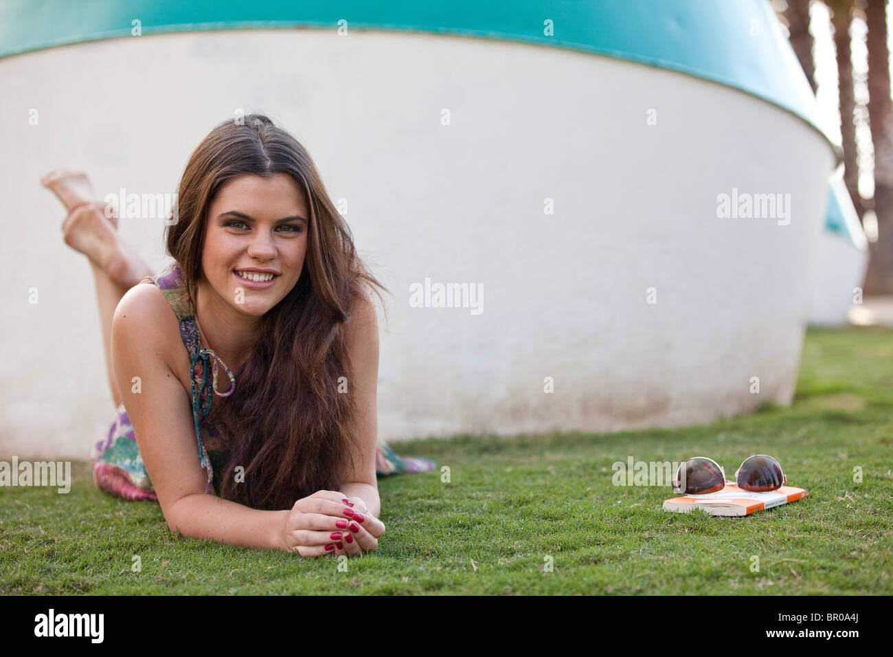 Young woman laying on grass in a park Stock Photo - Alamy