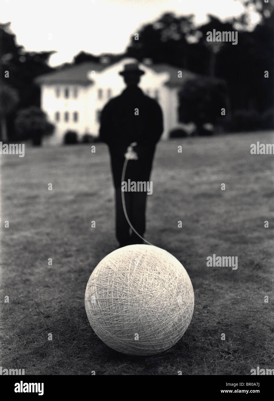 Executive 'man on suit'  Caucasian man black and white suit  holding a ball of string Stock Photo