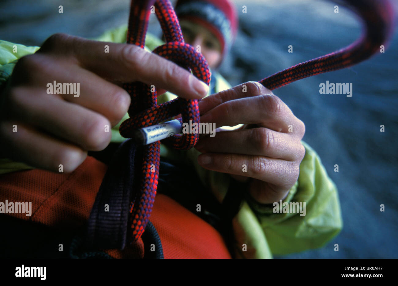 A female rock climber tying a figure eight knot in a climbing rope