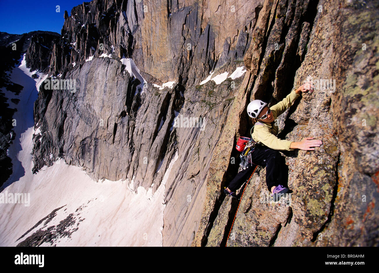 A female rock climber lead climbing a route in Rocky Mountain National
