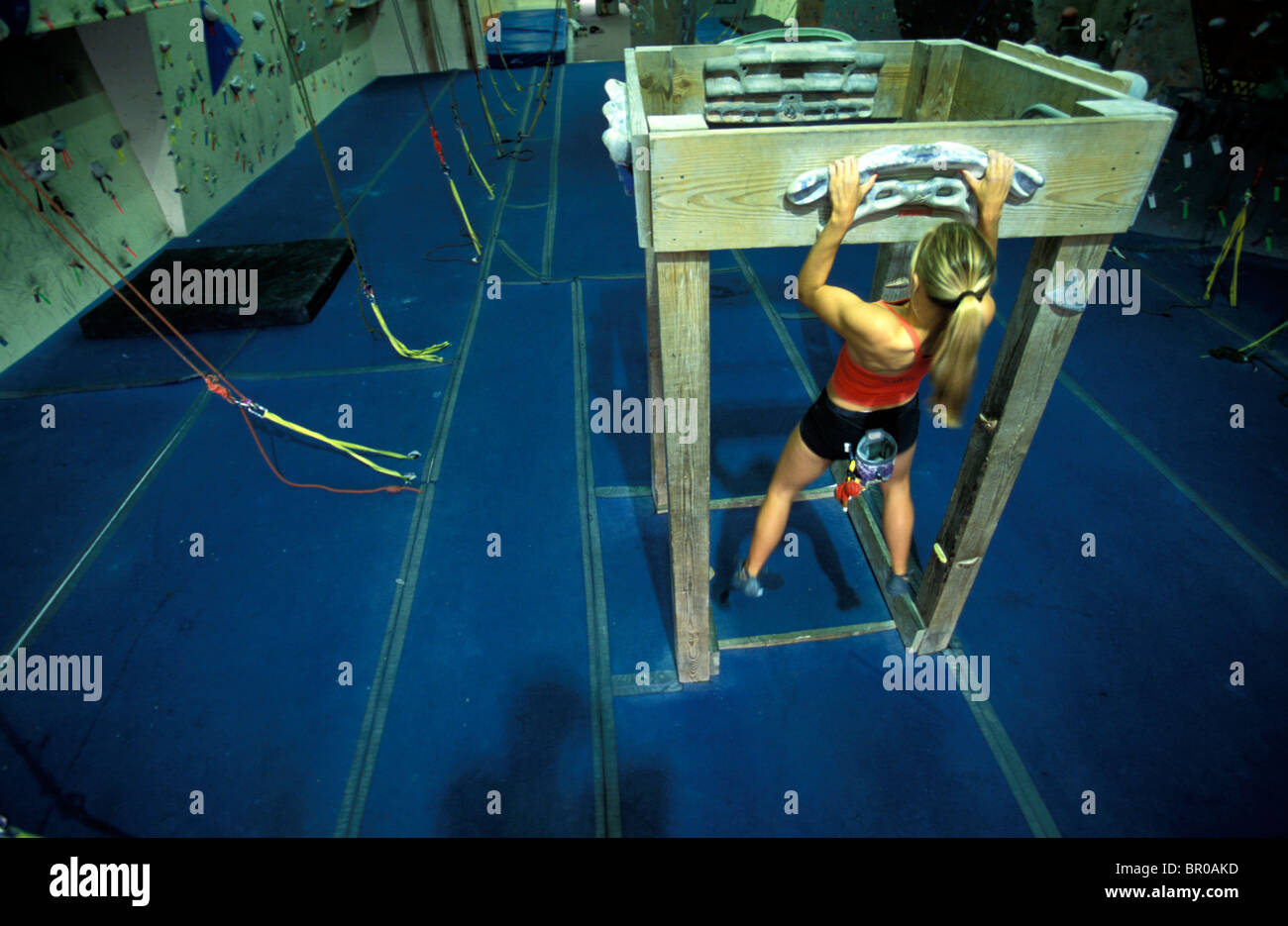 A young woman doing pull ups while climbing in an indoor climbing gym Stock Photo Alamy