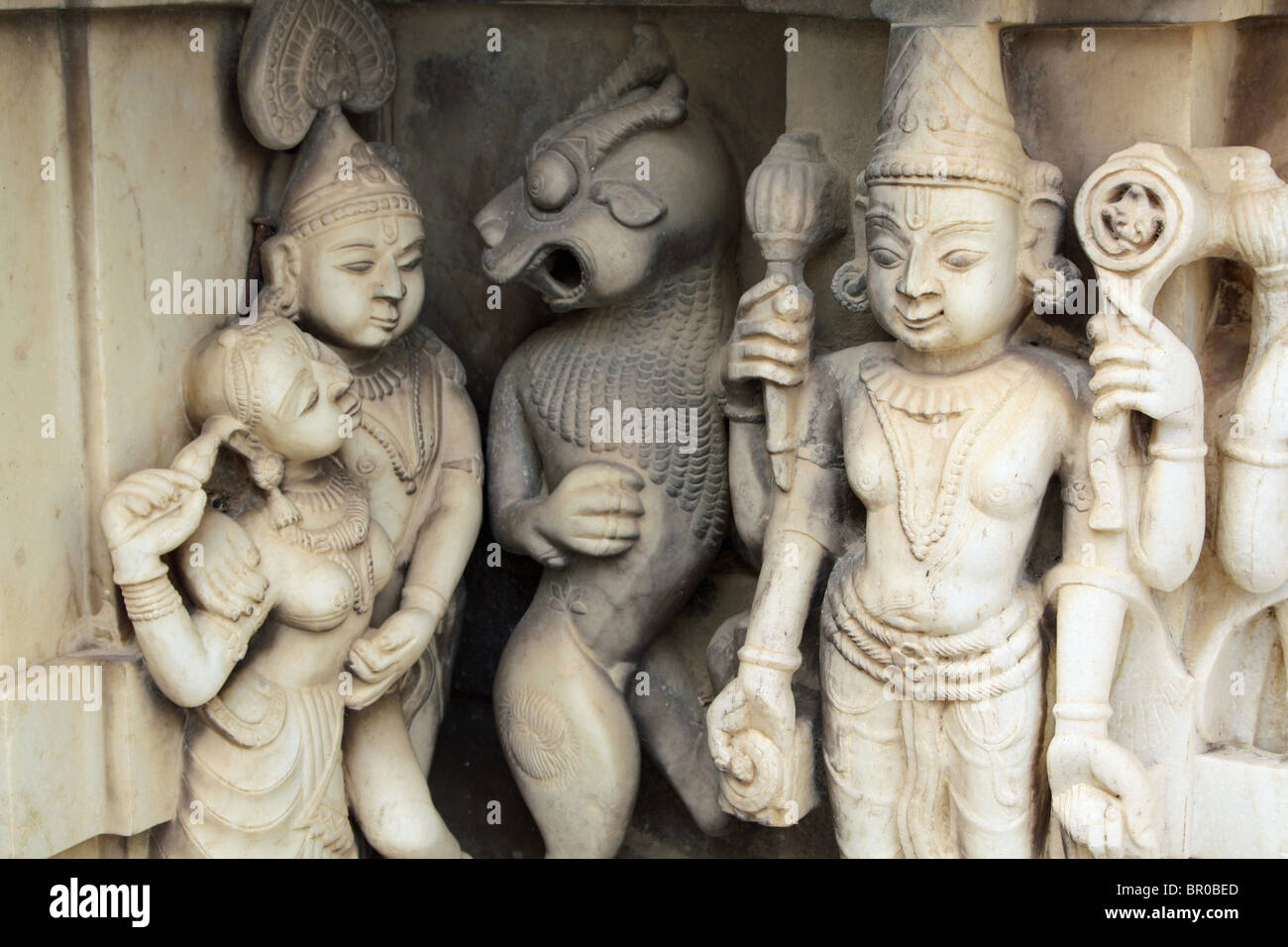Ancient white stone sculptures of Krishna and other gods and creatures decorating a Hindu temple in Udaipur, Rajasthan, India. Stock Photo