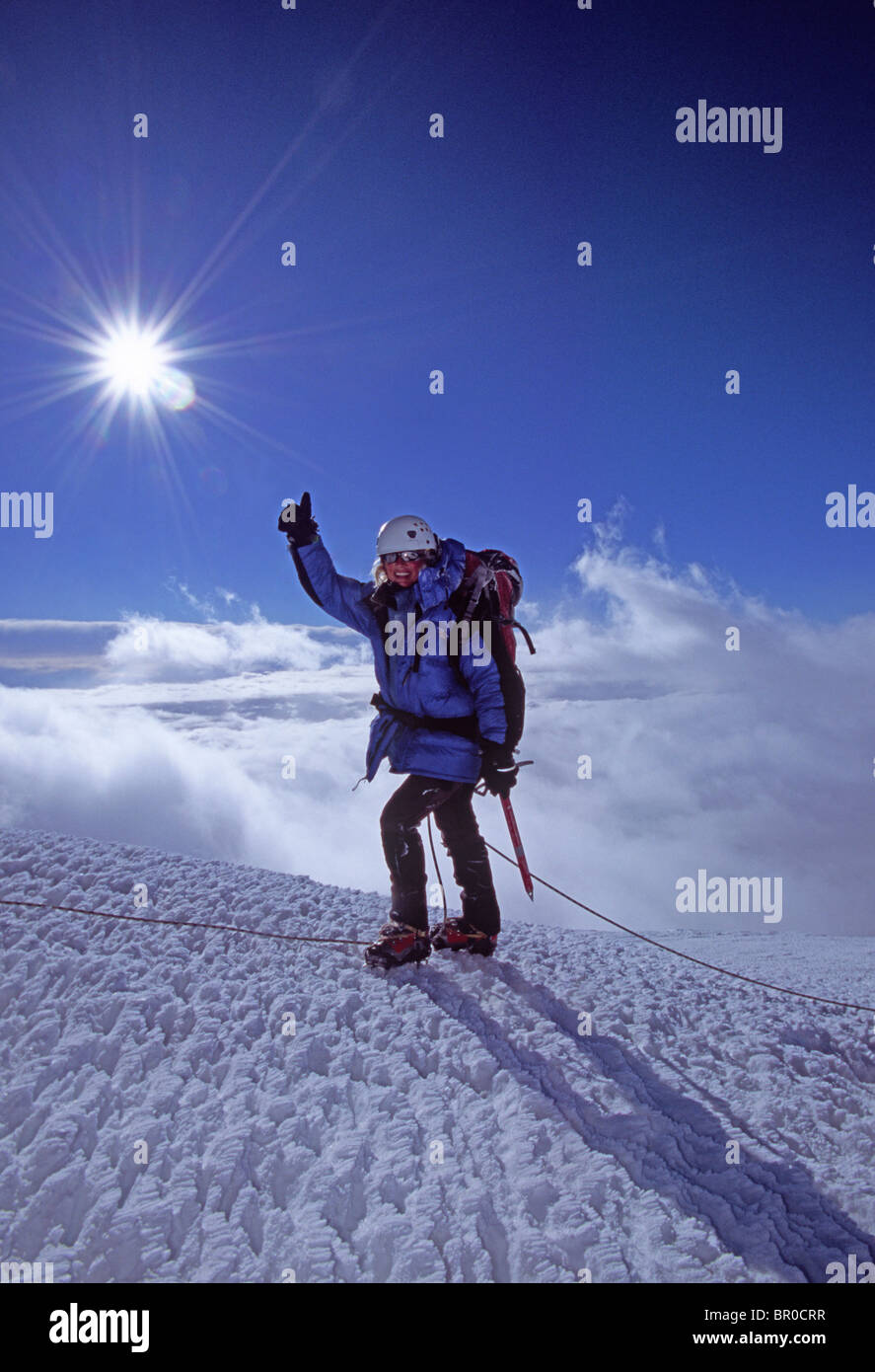 A female mountain climber reaches the summit of Mt. Rainier. Stock Photo