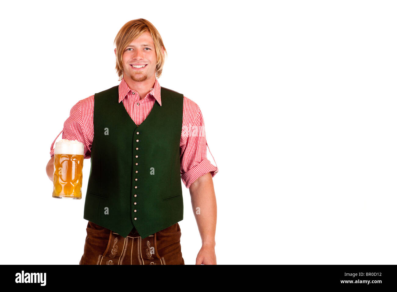 Bavarian man with leather trousers (lederhose) holds Oktoberfest beer stein in hand. Isolated on white background. Stock Photo