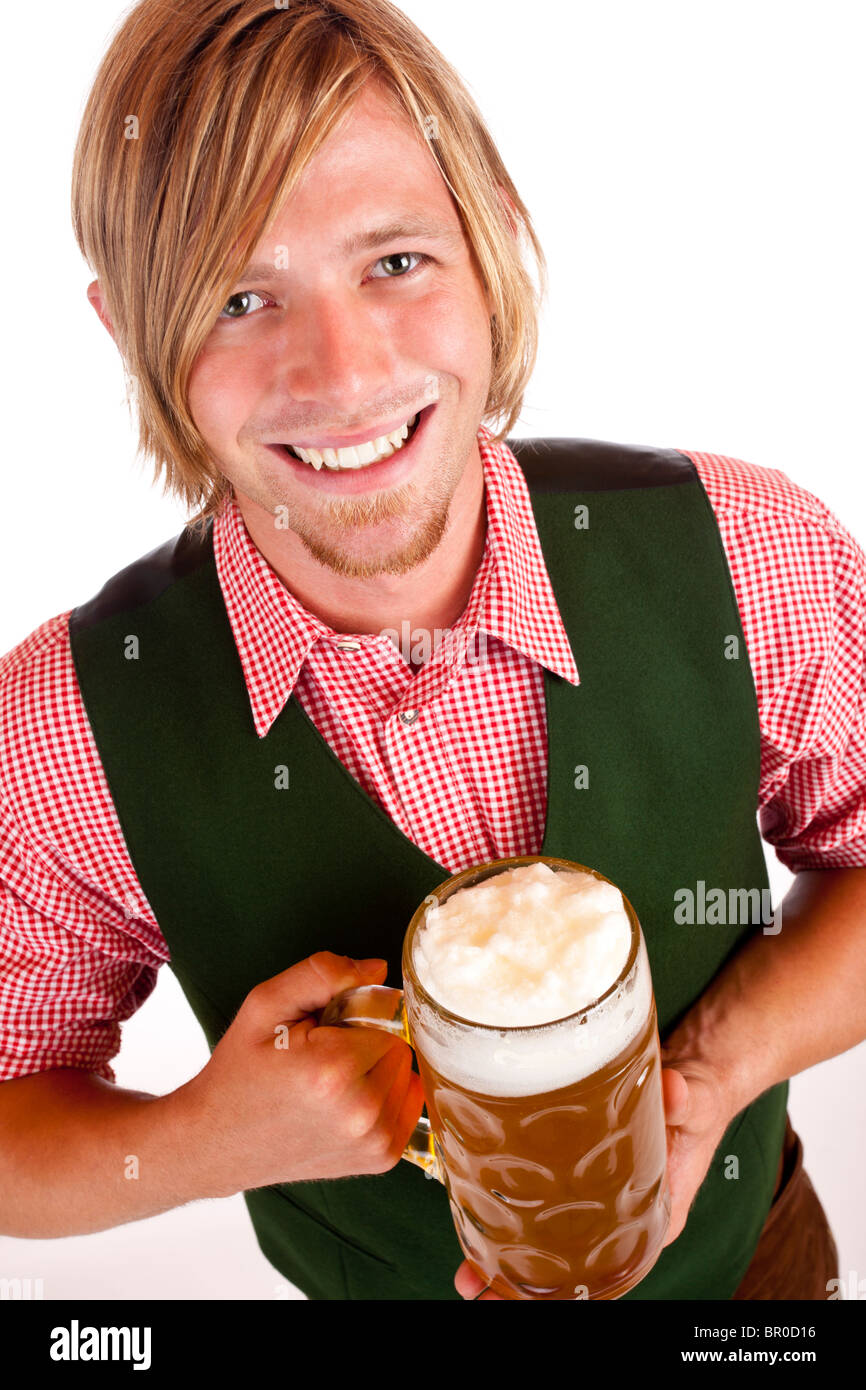Man  holds Oktoberfest beer stein and looks happy into camera. Isolated on white background. Stock Photo