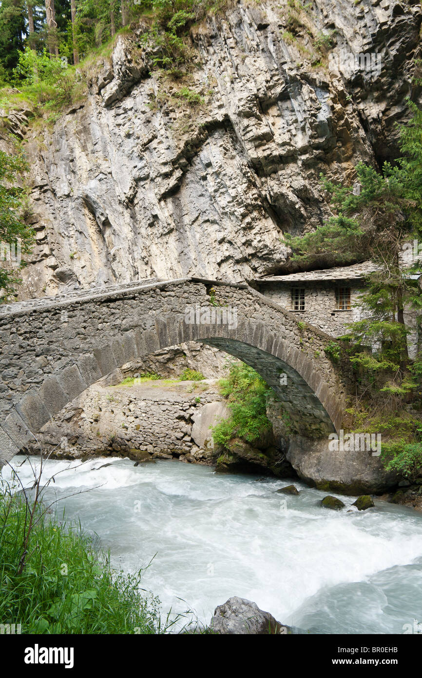 old stone bridge and home over Verney Dora in Pre Saint Didier, Aosta Valley, Italy Stock Photo