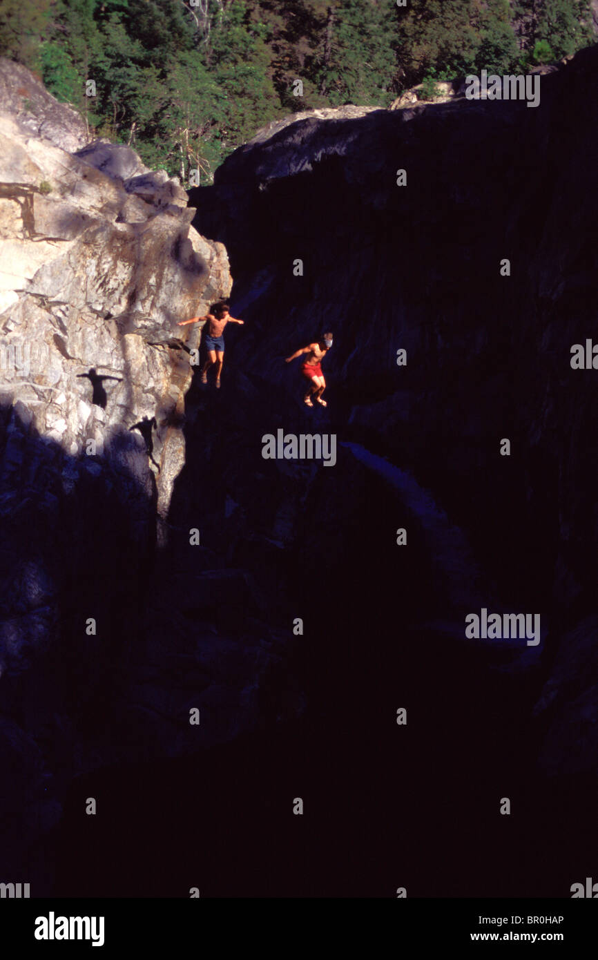 Two men jumping off a cliff into water at Emerald Pools on the South