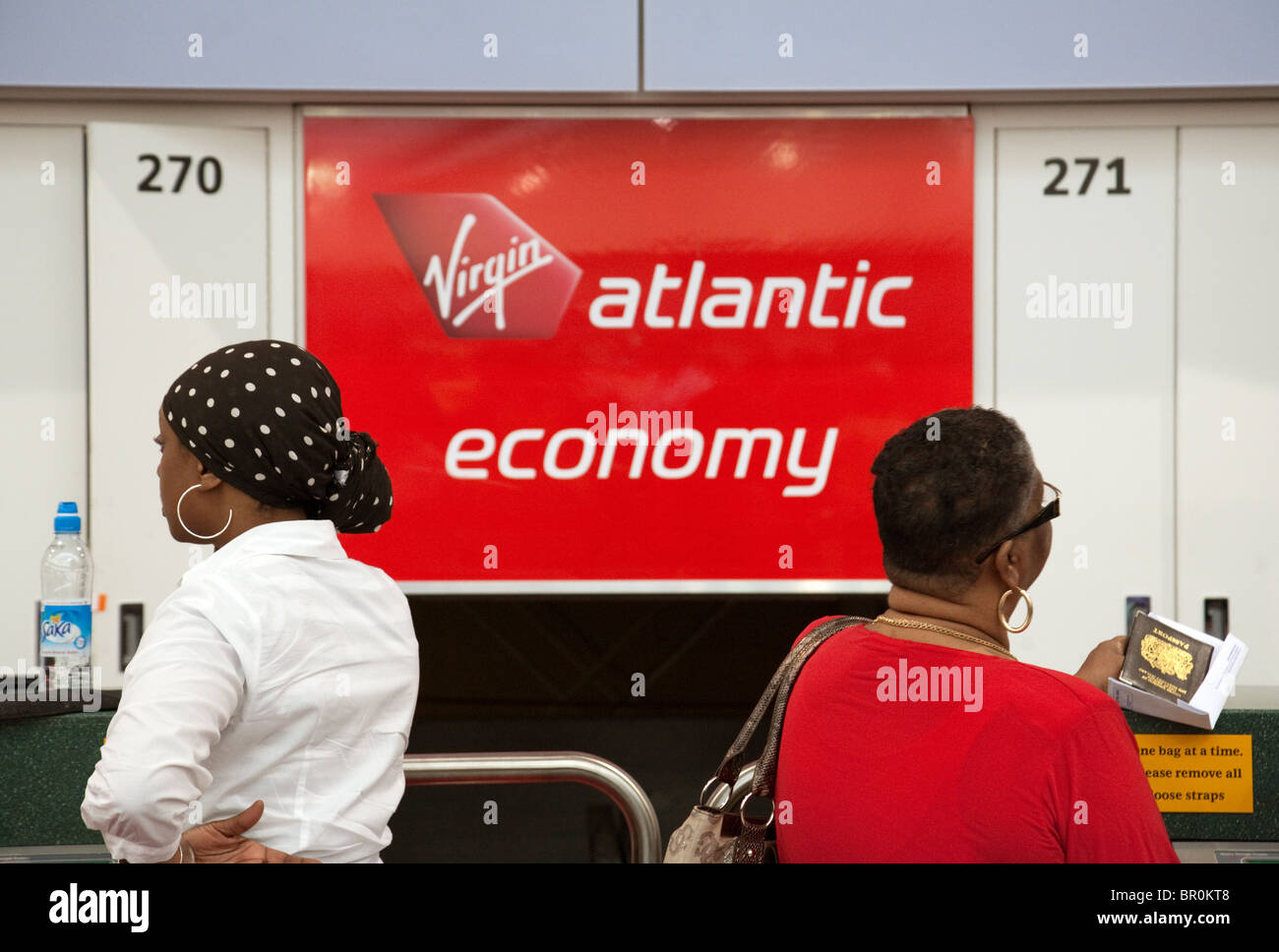 Two women at the check in desk, Virgin Atlantic, South terminal, Gatwick airport UK Stock Photo