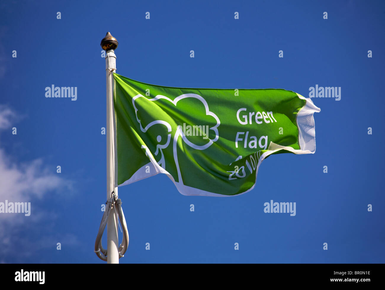 Green flag award flag flying at Bournemouth beaches set against blue sky Stock Photo