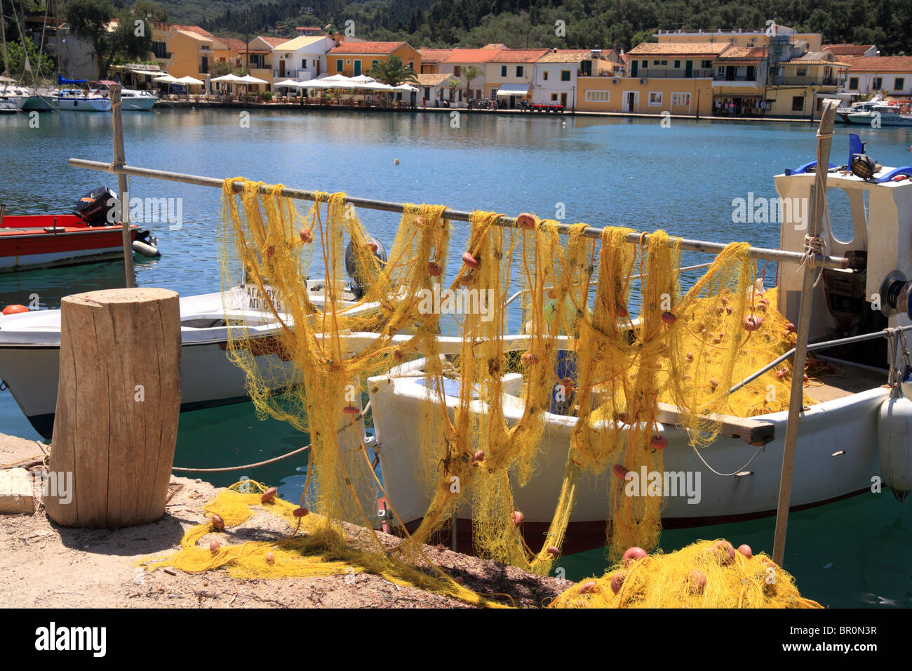 Fishing nets, Lakka harbour, Paxos, Ionian Island, Greece. Yellow fishing nets hanging out to dry or repair. Stock Photo
