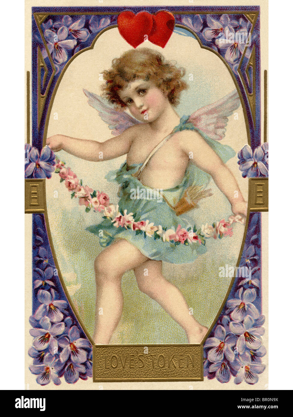 A vintage Loves Token Valentine card with a cherubim holding a flower garland Stock Photo