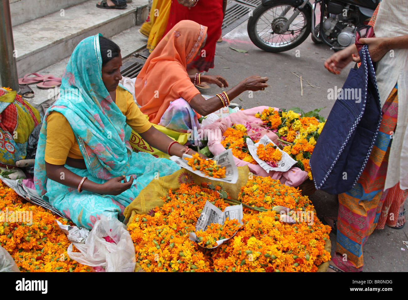 Women selling Marigold strings (garlands) at the Hindu temple for decorations during Diwali. Stock Photo